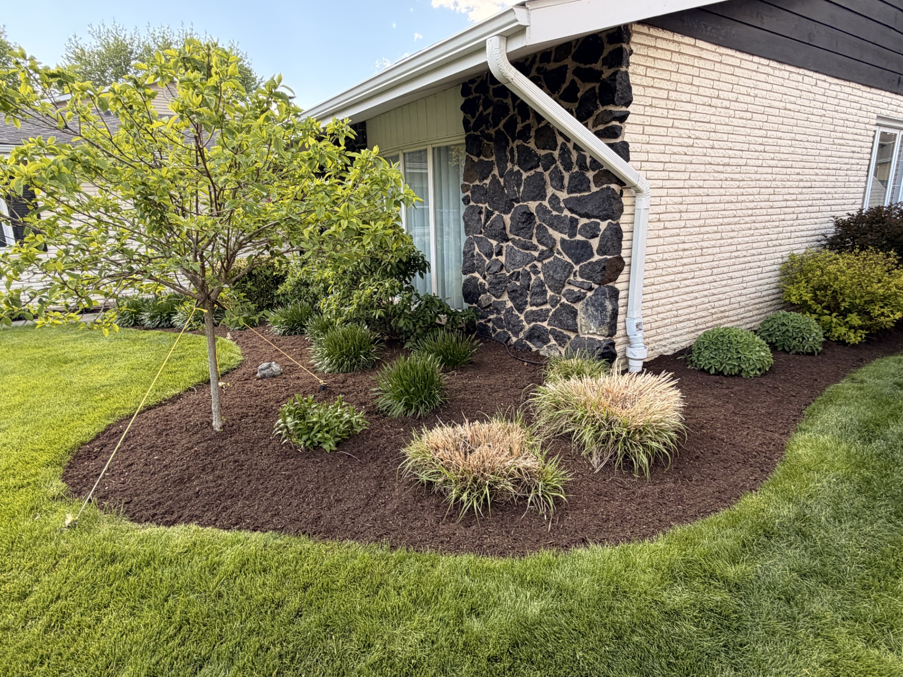 Stone-accent foundation bed with ornamental grasses
